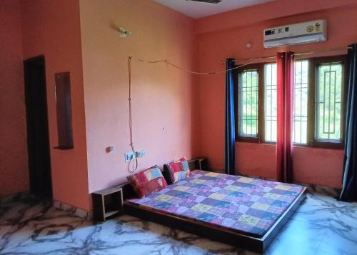 a bedroom with a bed in a room with orange walls at Laxmi Sadan - A RiverSide Homestay in KumhÄrsain