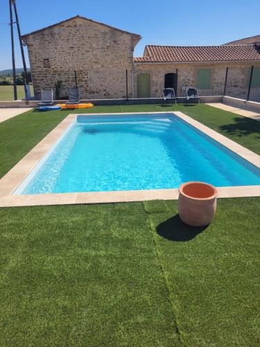 une piscine dans la cour d'une maison dans l'établissement Le Gîte Mas de Novis Vieux Mas du XVIIIe siècle, à Saint-Hilaire-de-Brethmas