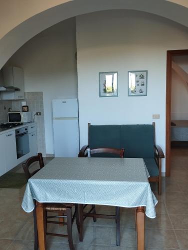 a table and chairs in a kitchen with a table and a table and a counter at Agriturismo Podere Montenero in Alberese