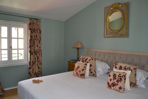 a bedroom with two beds and a mirror on the wall at Hotel Le Saint Paul in Saint-Paul-de-Vence