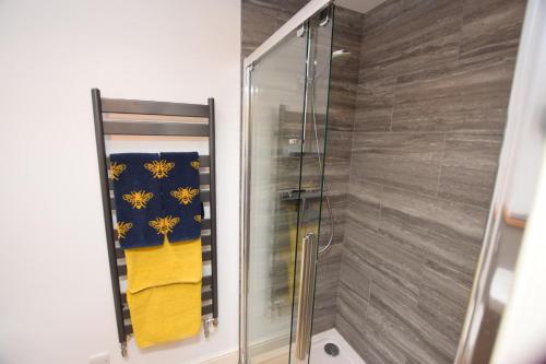 a shower stall with yellow towels in a bathroom at The Bothy in Carlton
