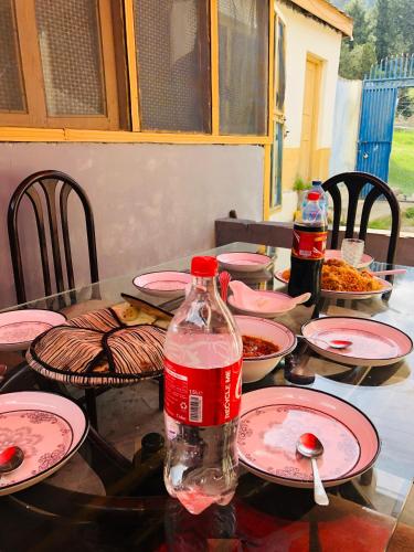 a table with plates and a bottle of water on it at 4 Season Guest House Naltar in Gilgit