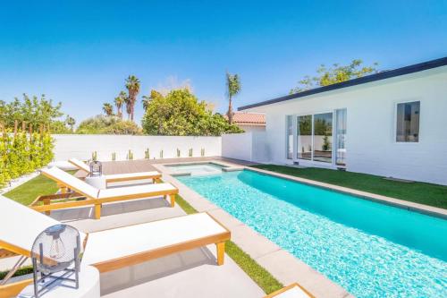 a backyard with a swimming pool and a house at White Pearl - Pool - Spa - Mountain Views in Palm Springs