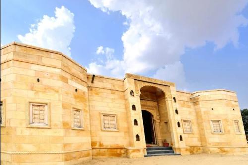 an old stone building with a blue sky in the background at The Desert Gateway Resort in Jaisalmer