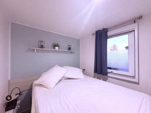 a bedroom with a white bed and a window at Au Ferret plage,piscines à 2 pas en famille by Vayny in Lège-Cap-Ferret