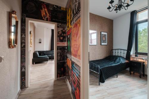 a hallway with a room with a bed and a wall with posters at Rock City Apartments Room 5150 in Essen