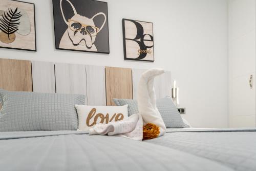 a white bedroom with a bed with art on the wall at Complejo Las Majadillas in Iznájar