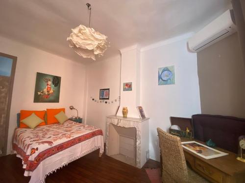 - une chambre avec un lit, une cheminée et un lustre dans l'établissement Appartement Duplex avec grande Terrasse en face d un ancien moulin a huile d olive ,climatisé 2 chambres, à Grasse