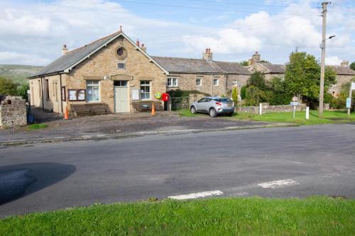 a car parked in front of a brick house at Lyncroft in Aysgarth