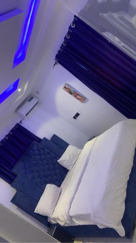 a bedroom with a bed with white sheets and pillows at Richj luxury apartment in Benin City