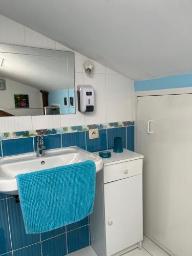 a blue and white bathroom with a sink and a mirror at Aux Cornettes in Beaune