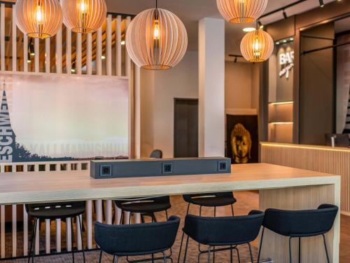 a bar in a restaurant with chairs and lights at B&B HOTEL Eschweiler in Eschweiler
