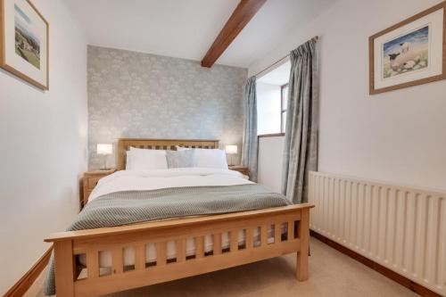 a bedroom with a bed and a window at Ballowfield Barn in Carperby
