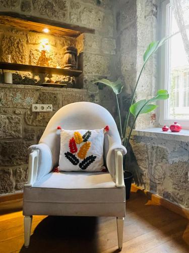 a white chair with a pillow in a room at Otel Kallista in Alacati