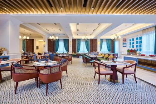 a restaurant with tables and chairs in a room at Sarovar Premiere Amritsar in Amritsar