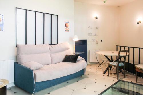 un salon avec un canapé et une table dans l'établissement Charming themed loft - Paris Cosmic - Paris 18, à Paris
