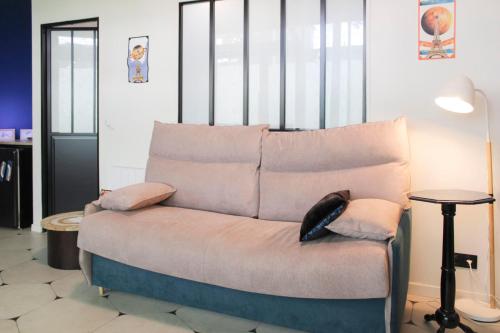 - un canapé avec un chat assis dans une pièce dans l'établissement Charming themed loft - Paris Cosmic - Paris 18, à Paris