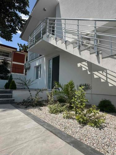 a white house with a staircase on the side of it at Aqualux Luxury in Star Dojran