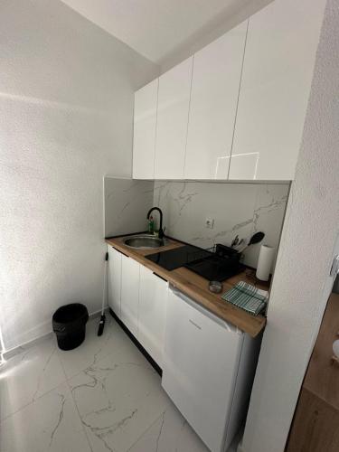 a white kitchen with a sink and a counter at Aqualux Luxury in Star Dojran
