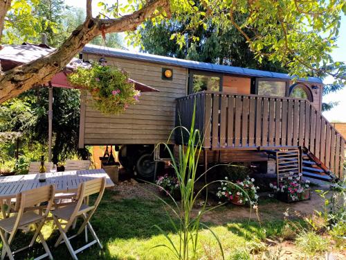 an old rv with a table and chairs in a yard at Na Vlně maringotek in Přítluky