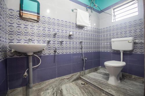 a bathroom with a toilet and a sink at Super Capital O Priyanshu in Siliguri