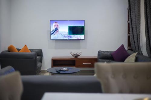 a living room with two couches and a table at Citadin Apart Hotel Douala in Douala