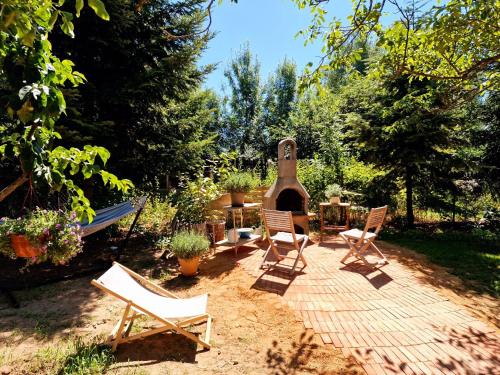 a patio with chairs and a fireplace in a yard at Na Vlně maringotek in Přítluky