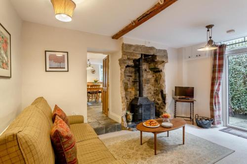 a living room with a couch and a stone fireplace at High Houses in Wath