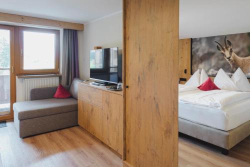 a hotel room with a bed and a tv at Hotel Acherl in Achenkirch