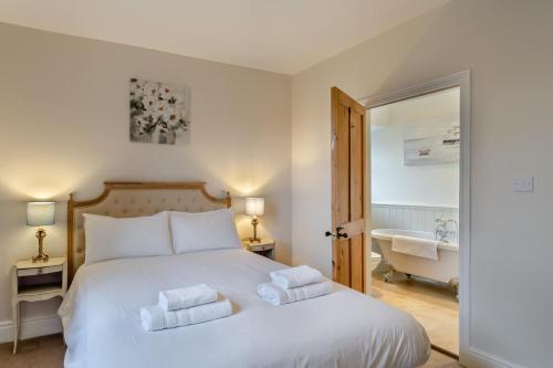 a bedroom with a white bed with towels on it at High Houses in Wath