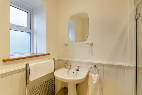 a white bathroom with a sink and a mirror at High Houses in Wath