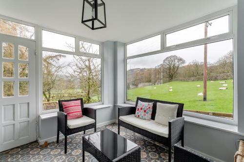 a room with windows and chairs and a view of a field at High Houses in Wath