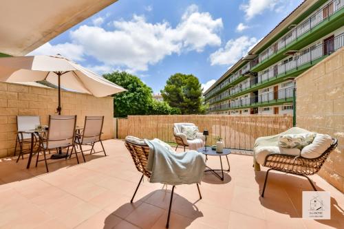 un patio con sedie, tavoli e un ombrellone di Casalfas - Élégance, Piscine, Emplacement idéal by LG Home conciergerie a Alfaz del Pi