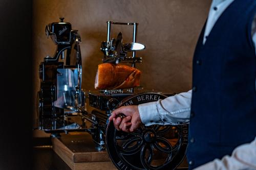 a man with his hand on the wheel of a sewing machine at Hotel Alpenkönig in Oberstaufen