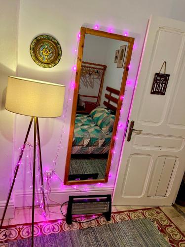 a bedroom with a mirror with pink lights at Joli appartement in Tunis