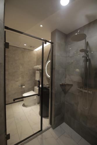 a bathroom with a shower stall and a toilet at LOTUS BLU HOTEL Naga 
