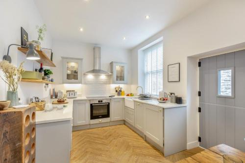 a kitchen with white cabinets and a stove top oven at Wayside in Carperby