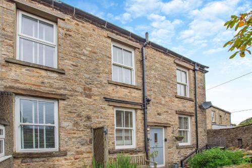 an old brick house with white windows at Wayside in Carperby