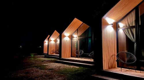 a row of wooden buildings lit up at night at The Landscape Barn Homes in Râşnov