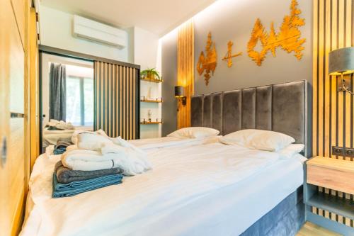 a bedroom with a large bed with white sheets at Omega Lake Apartments in Olsztyn