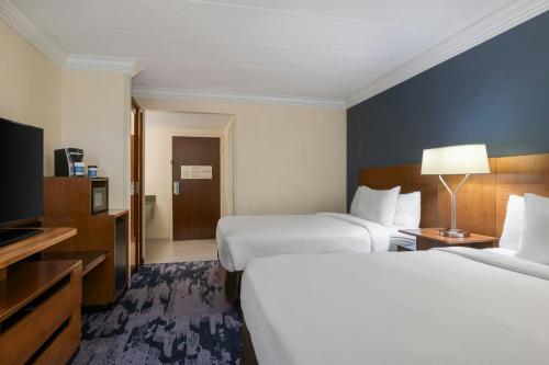 a hotel room with two beds and a television at Fairfield by Marriott Inn & Suites Herndon Reston in Herndon
