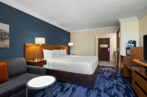 a hotel room with a bed and a couch at Fairfield by Marriott Inn & Suites Herndon Reston in Herndon
