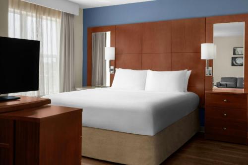 a bedroom with a large bed and a television at Residence Inn by Marriott Houston Katy Mills in Katy