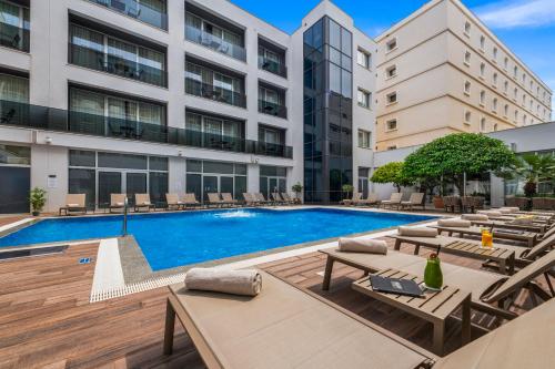 a swimming pool with lounge chairs and a building at Hotel Lero in Dubrovnik
