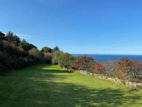 a green field with the ocean in the background at 1 Browcote Cottage in Ravenscar