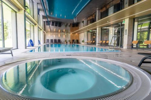 a large swimming pool in a building at Omega Lake Apartments in Olsztyn