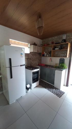 a kitchen with a white refrigerator and a sink at Casa do Carlos - Boipeba in Ilha de Boipeba