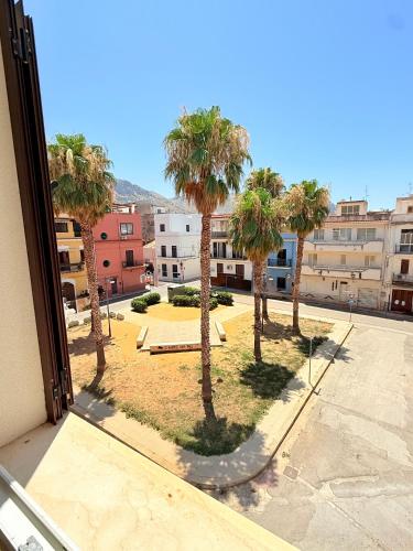 a view of a courtyard with palm trees from a window at Casa Ferrante in Cinisi