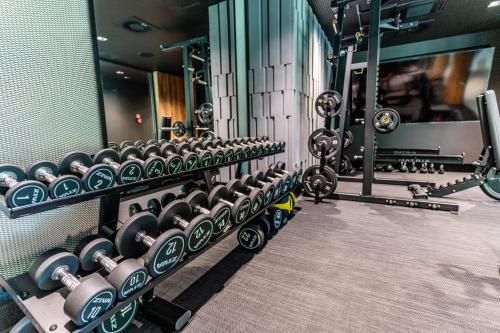 a gym with rows of dumbbells on the wall at Omega Lake Apartments in Olsztyn