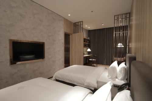 a hotel room with two beds and a flat screen tv at LOTUS BLU HOTEL Naga 